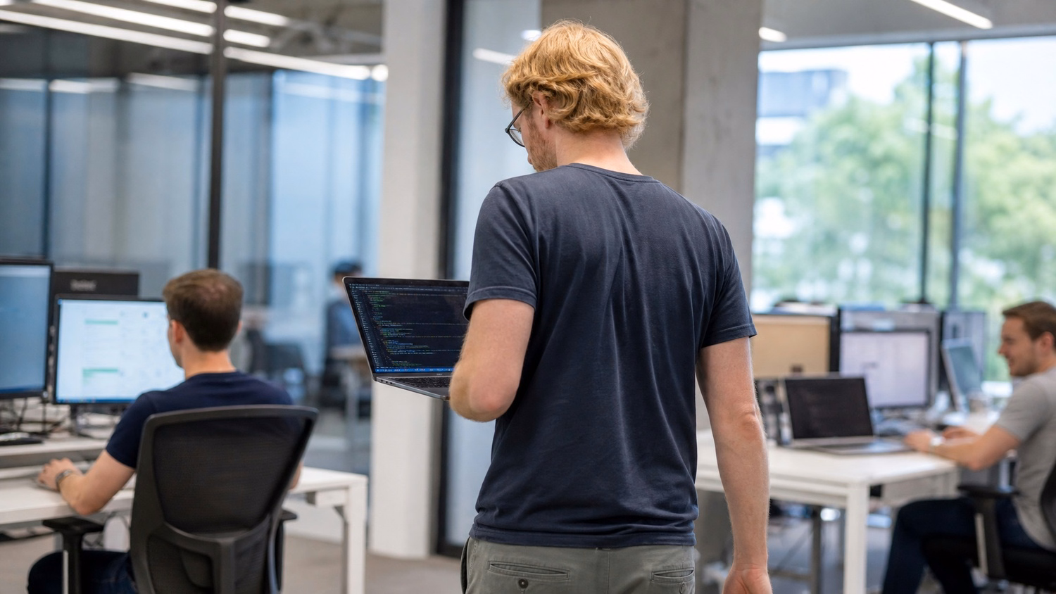 Man carrying open laptop with code visible