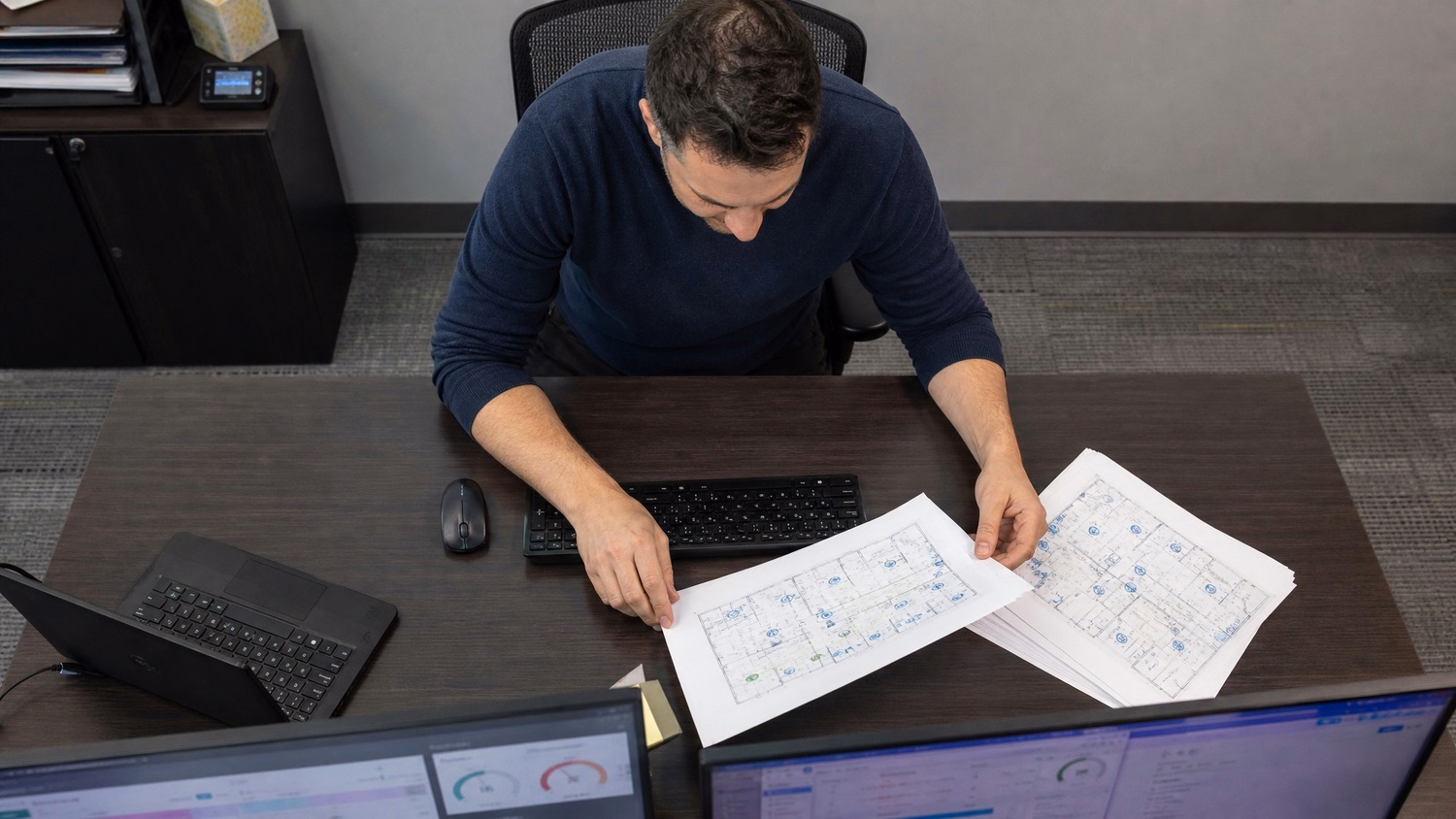 Man organizing Wi-Fi access point diagrams at desk 57 chars