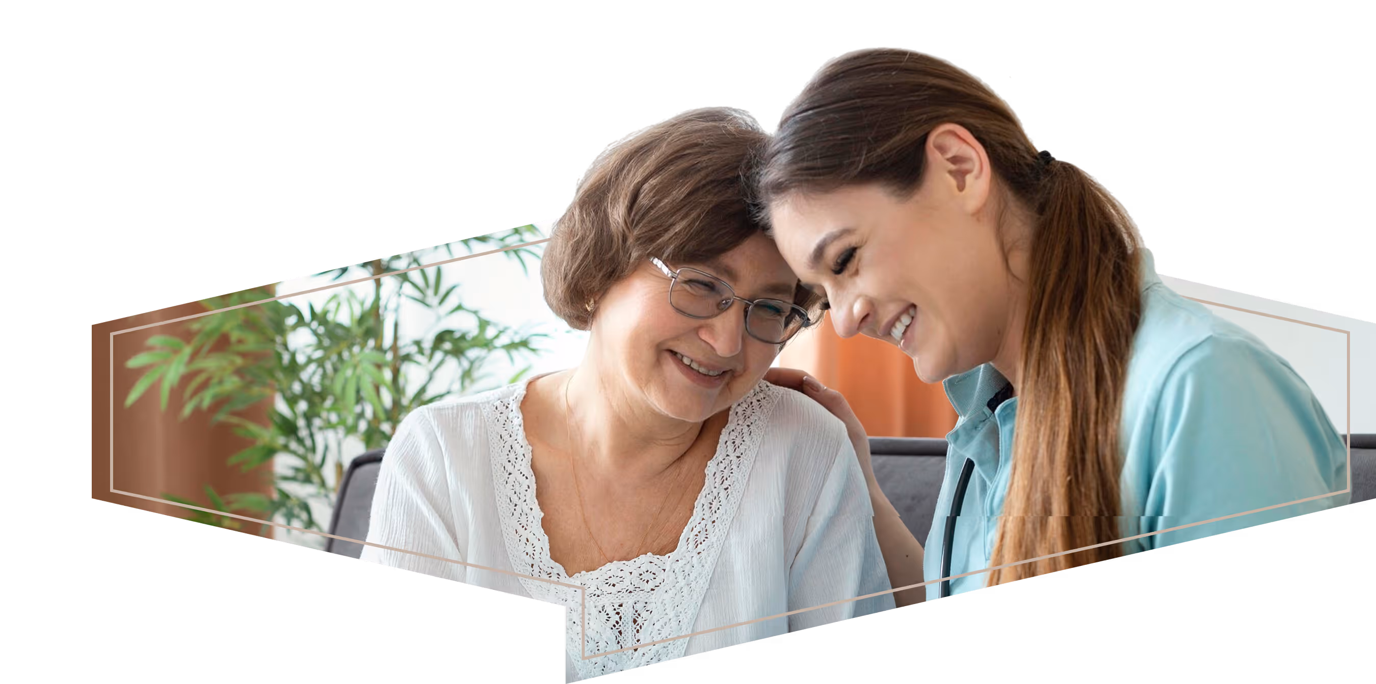 Smiling elderly woman and young female caregiver lean heads together in warm, supportive moment.