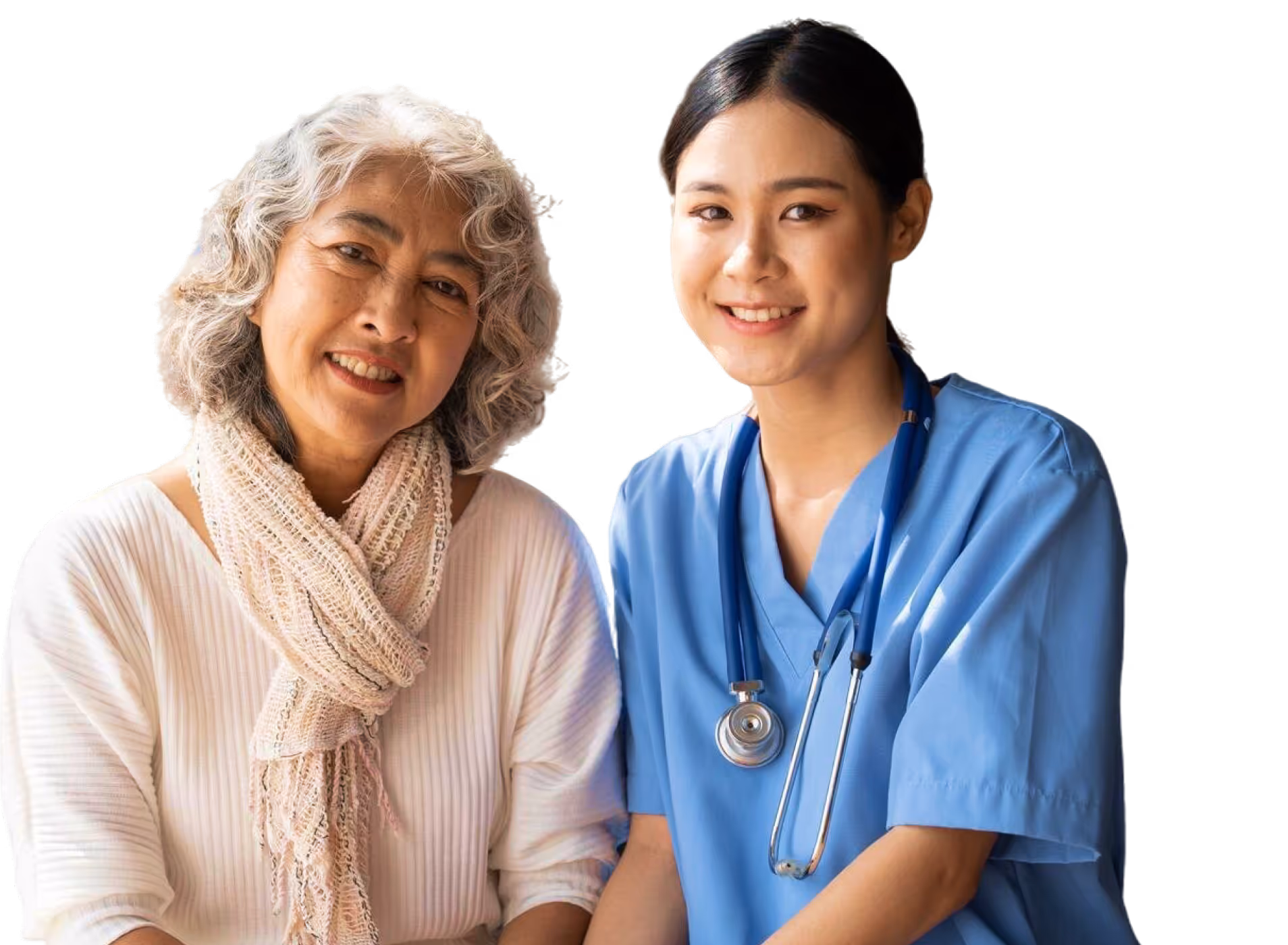 Smiling elderly woman sitting beside a female nurse in blue scrubs with a stethoscope.