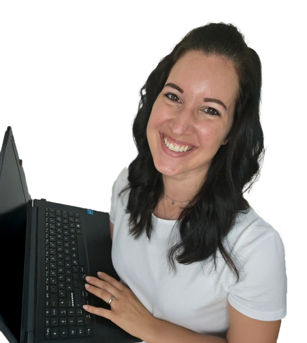 Ich tippend an meinem Laptop in der Hand und lächelnd in die Kamera schauend.