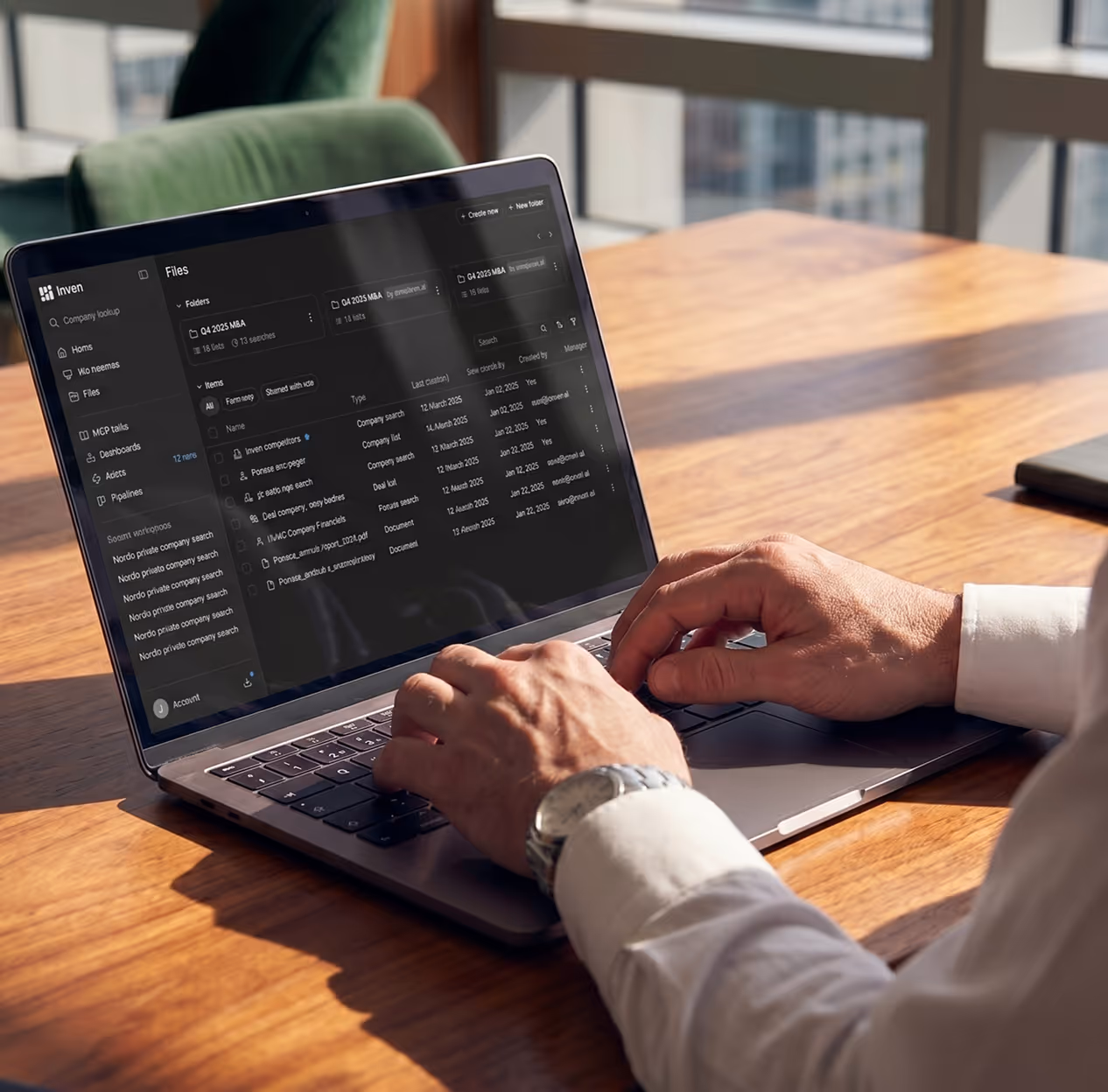 Person typing on a laptop showing a business files and company search dashboard screen.