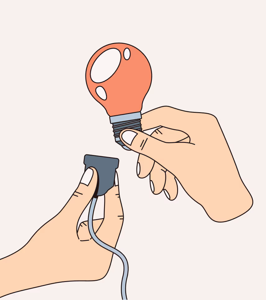 Two hands holding a red light bulb and a plug about to be connected.