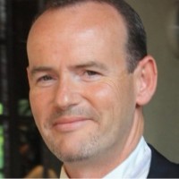 Portrait d'un homme souriant à cheveux courts et peau claire.