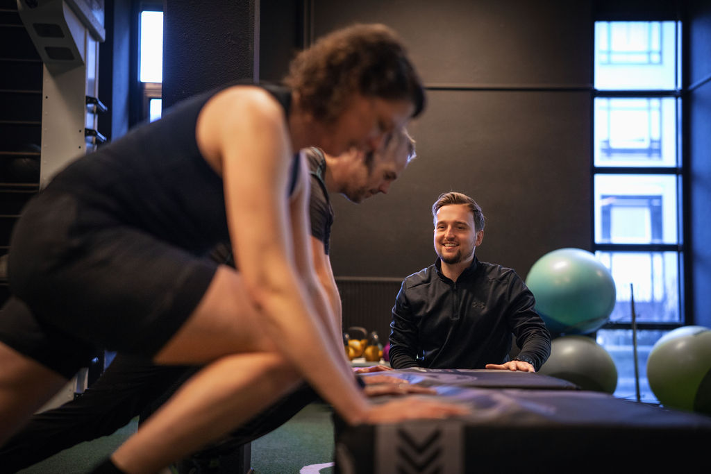 Fysiotherapeut motiveert deelnemers in groepstraining