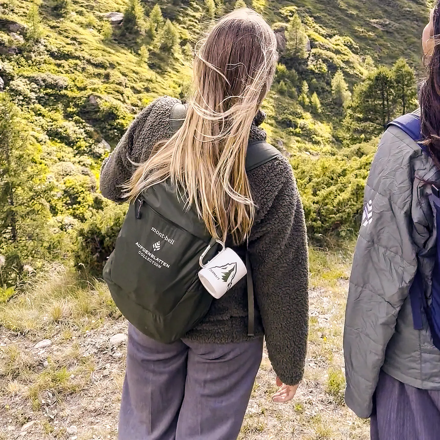 Zwei Wanderinnen mit Rucksäcken auf einem Bergweg oberhalb von Zermatt