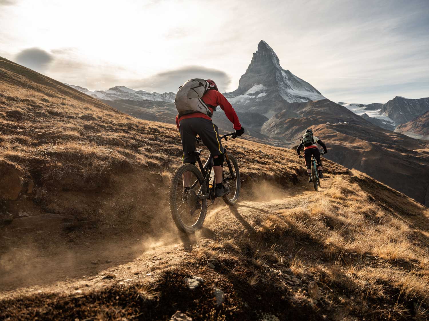 Zwei Mountainbiker auf einem Trail oberhalb von Zermatt mit Blick auf das Matterhorn
