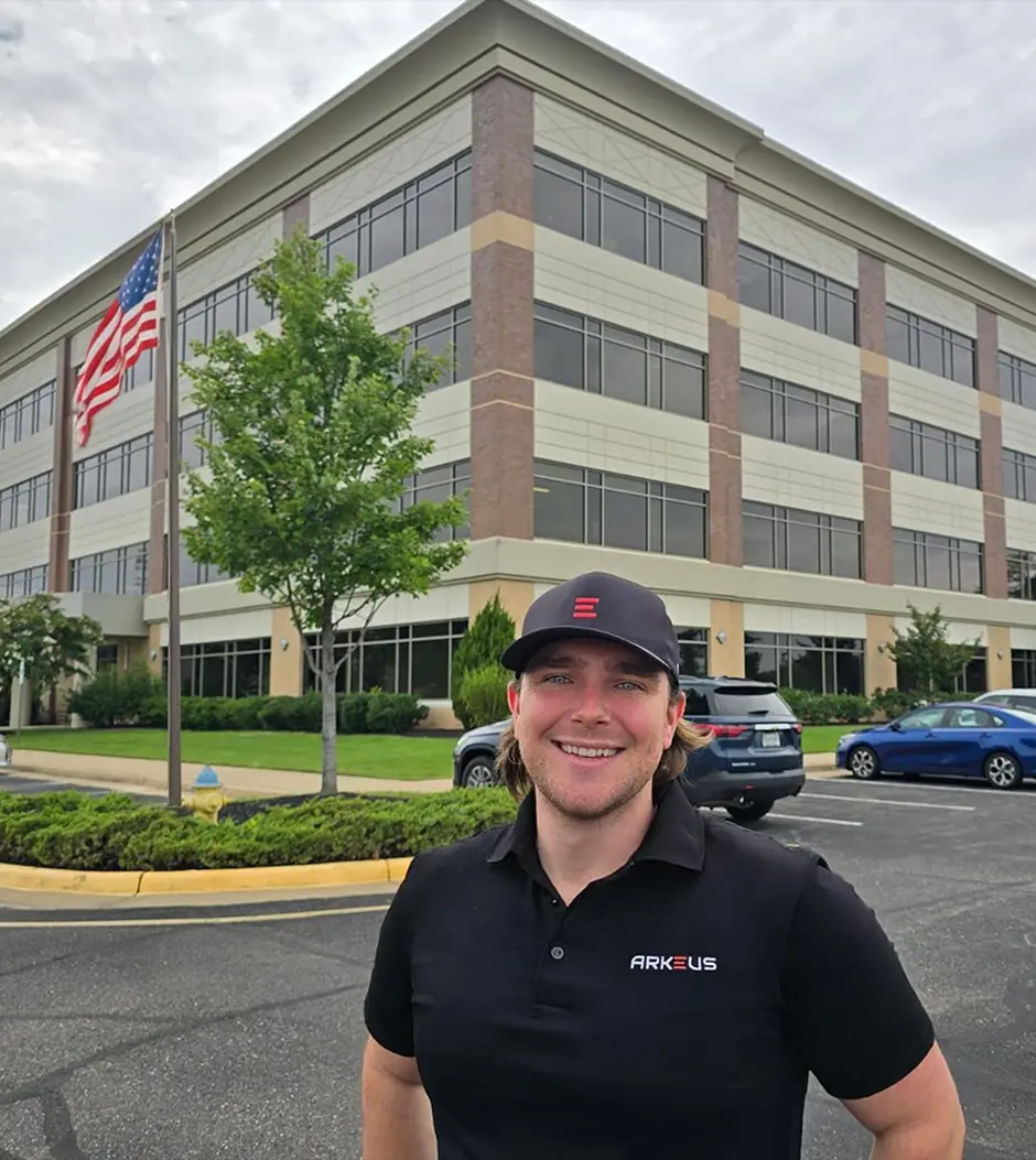 A man standing in front of a large building.