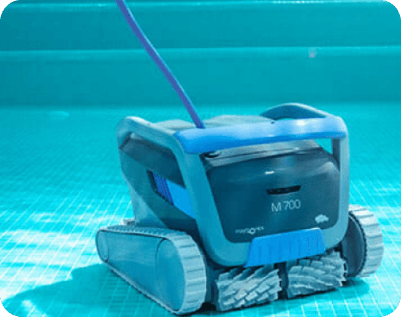 M700 robotic pool cleaner with blue and black body resting on a tiled pool floor underwater.