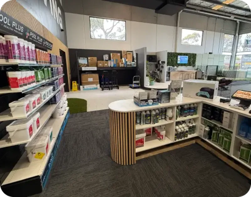 Interior of a store with pool supplies on shelves and a curved counter displaying various products.