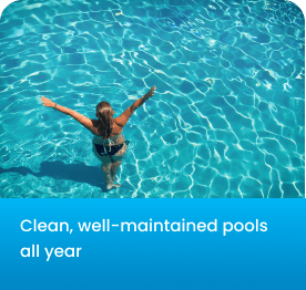 Woman with arms raised standing in clear, blue, well-maintained swimming pool water.