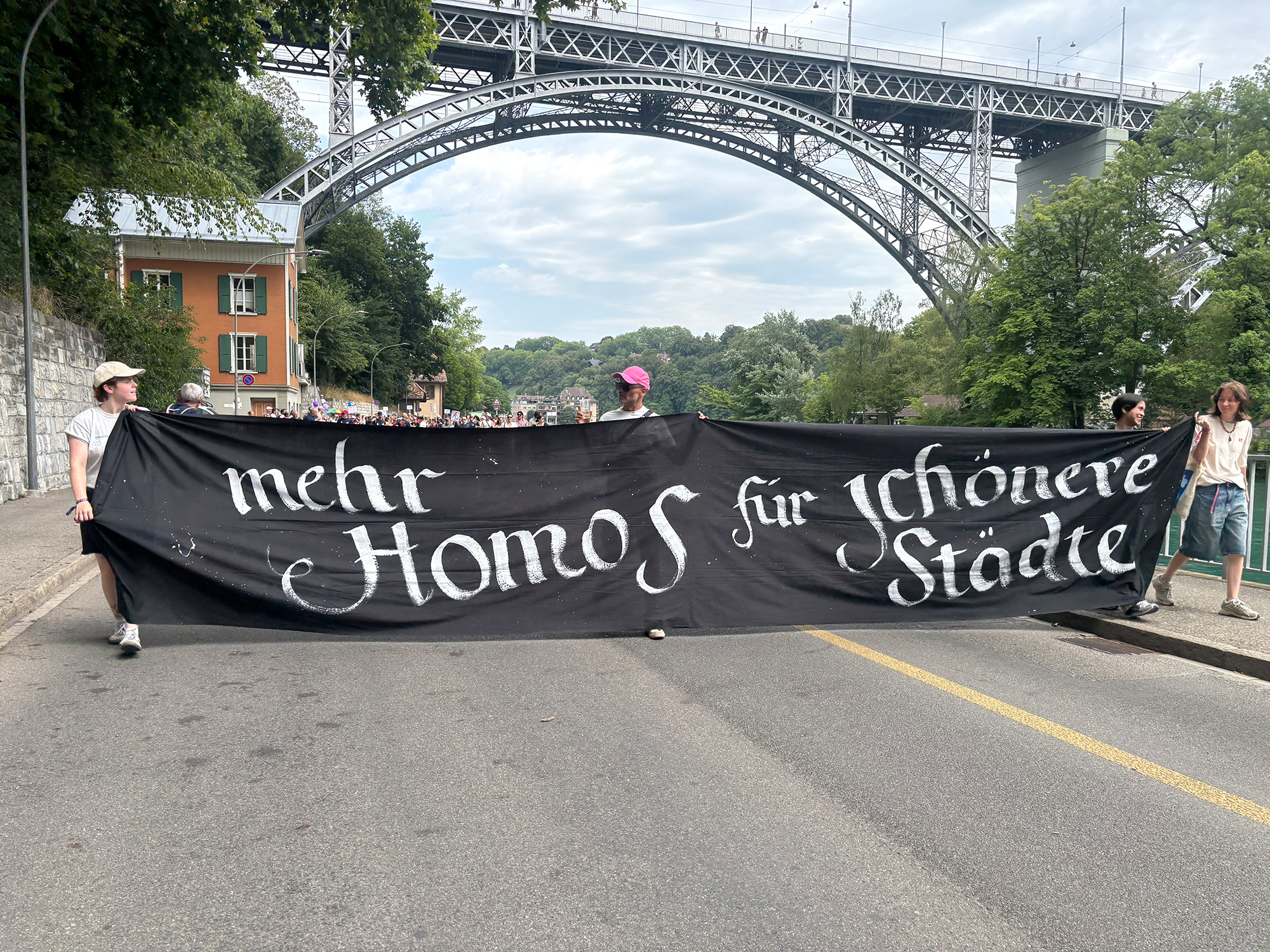Banner von Queersicht an der Pride Bern: ‚Mehr Homos für schönere Städte'.