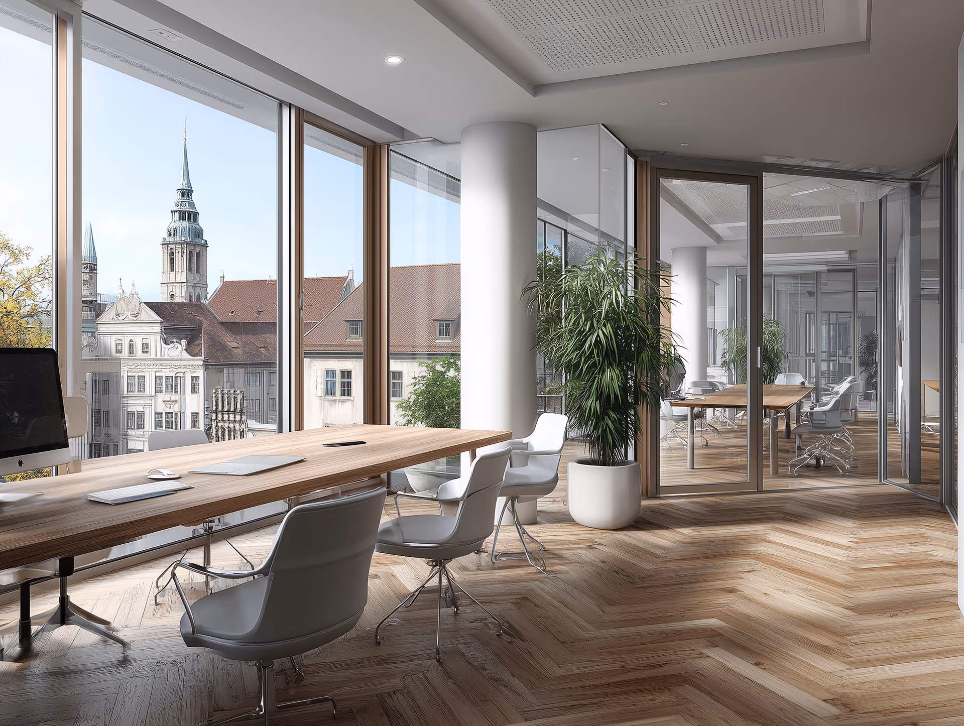 Modernes Büro mit großen Fenstern, Holzfußboden, Besprechungstisch, weißen Stühlen und Blick auf historische Gebäude.