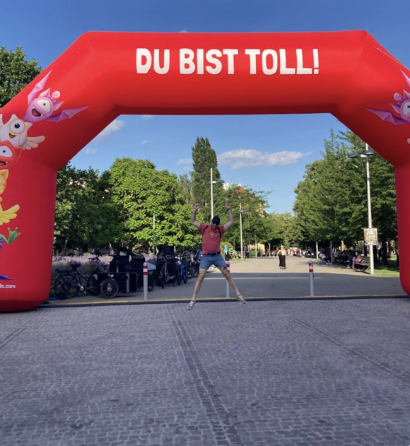 Andreas springt vor einem aufblasbaren roten Tor mit der Aufschrift: du bist toll!