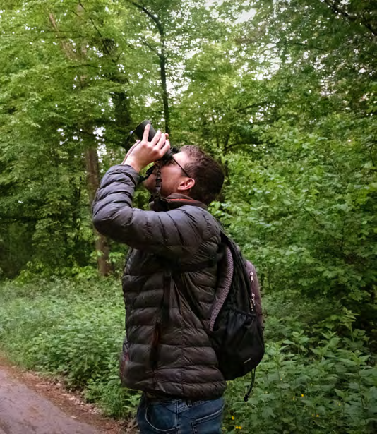 Kalle steht im Wald und richtet seine Kamera nach oben