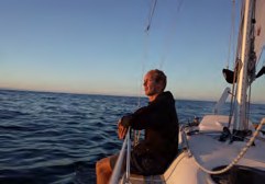 Simon sitzt im Cockpit und schaut auf das Meer