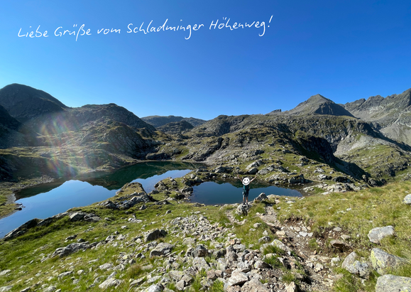 Blick über zwei Bergseen am Schladminger Höhenweg, mit handgeschriebenem Gruß im Bild