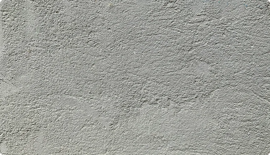 Nahaufnahme einer grau strukturierten, rauen Putzoberfläche.