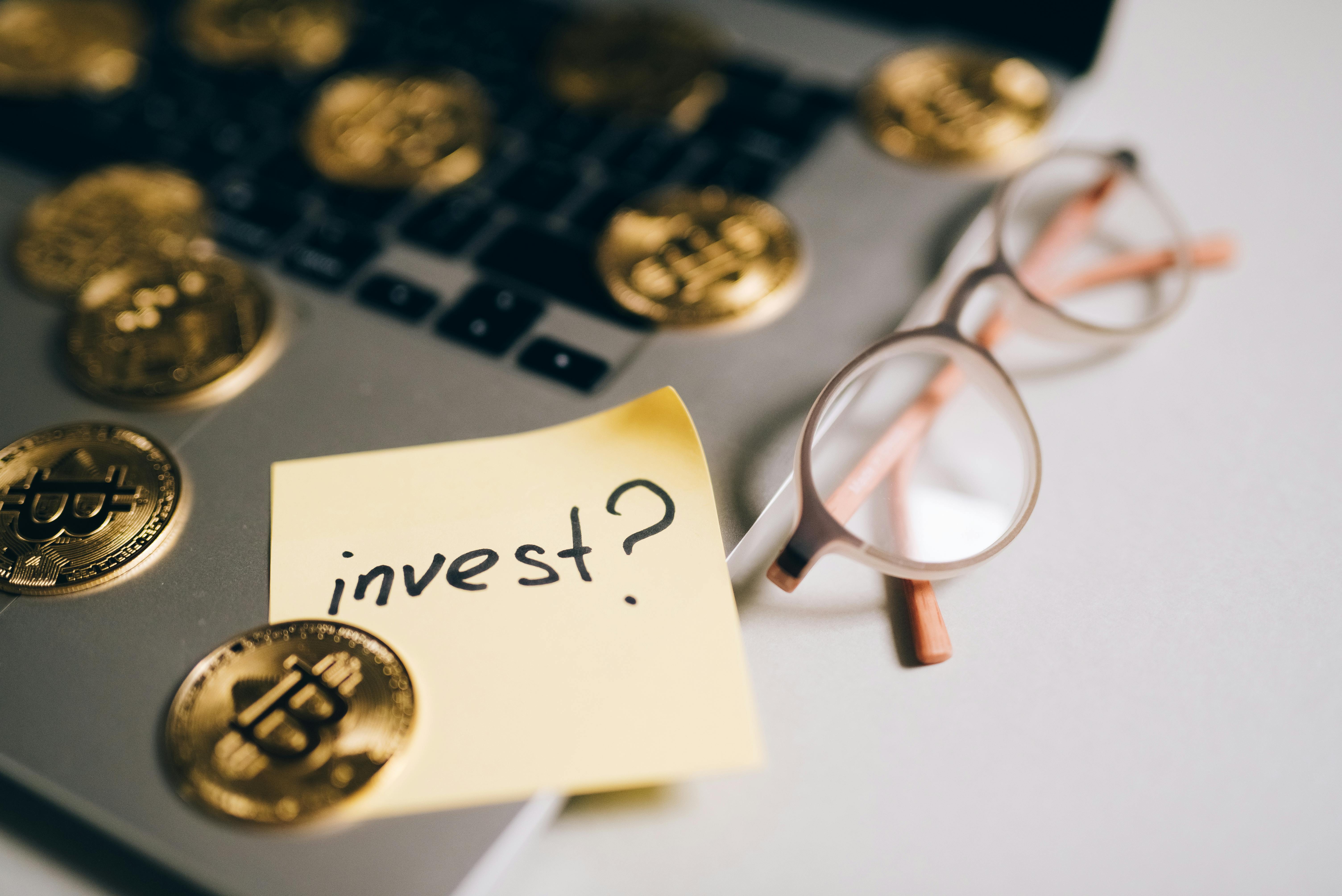 Pièces, lunettes et pense-bête portant la question invest