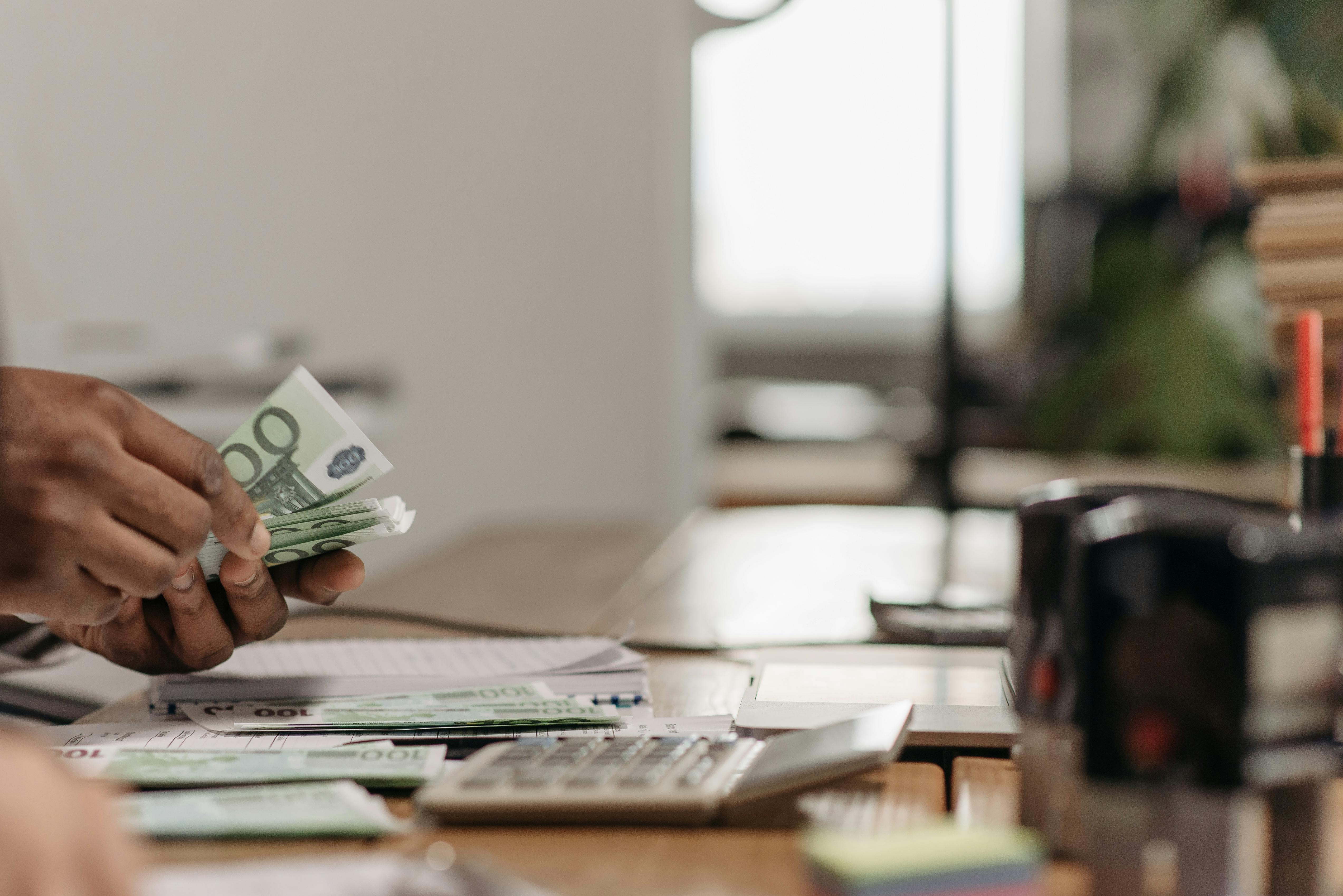 Personne comptant des billets à son bureau