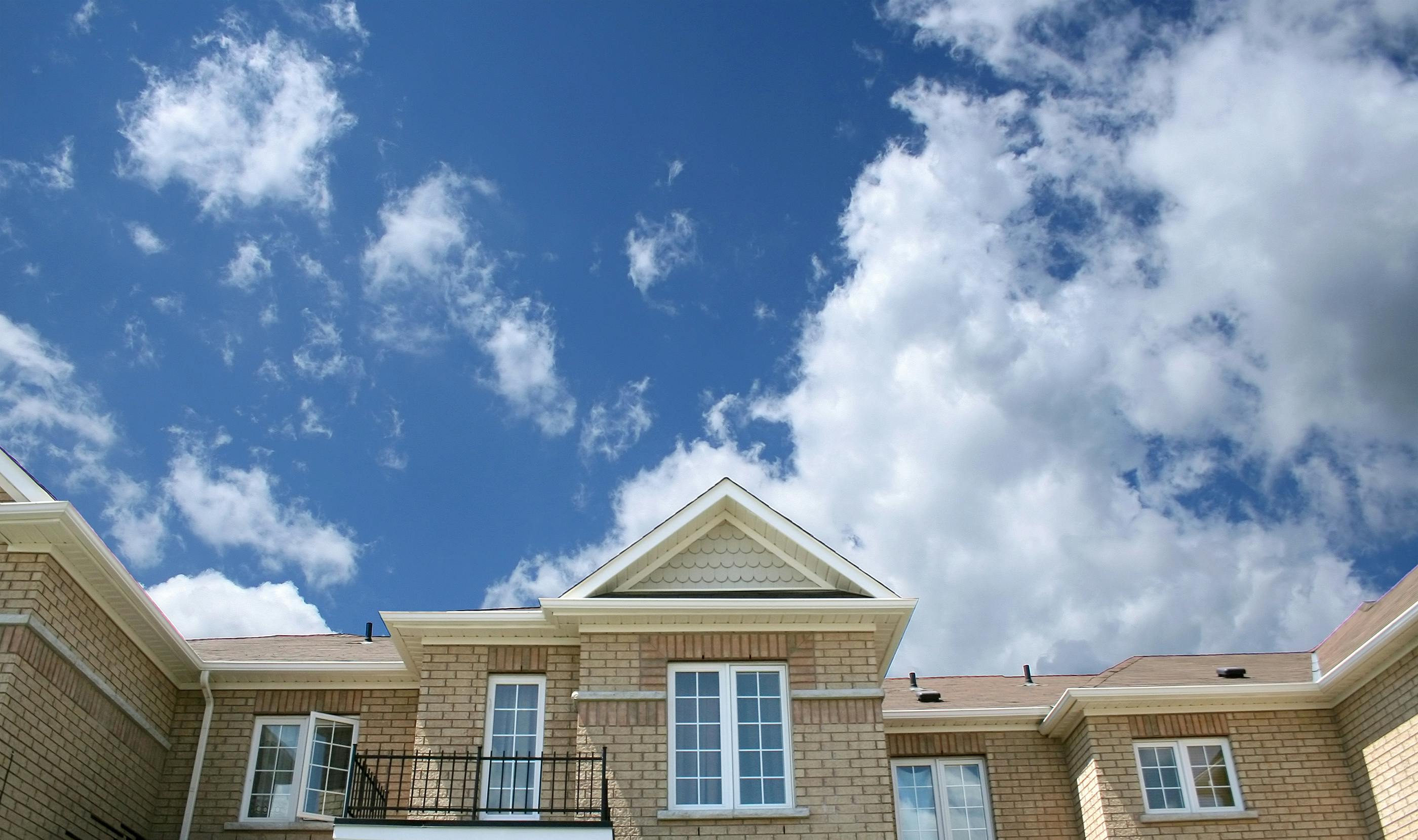 Toits de maisons mitoyennes sous un ciel nuageux