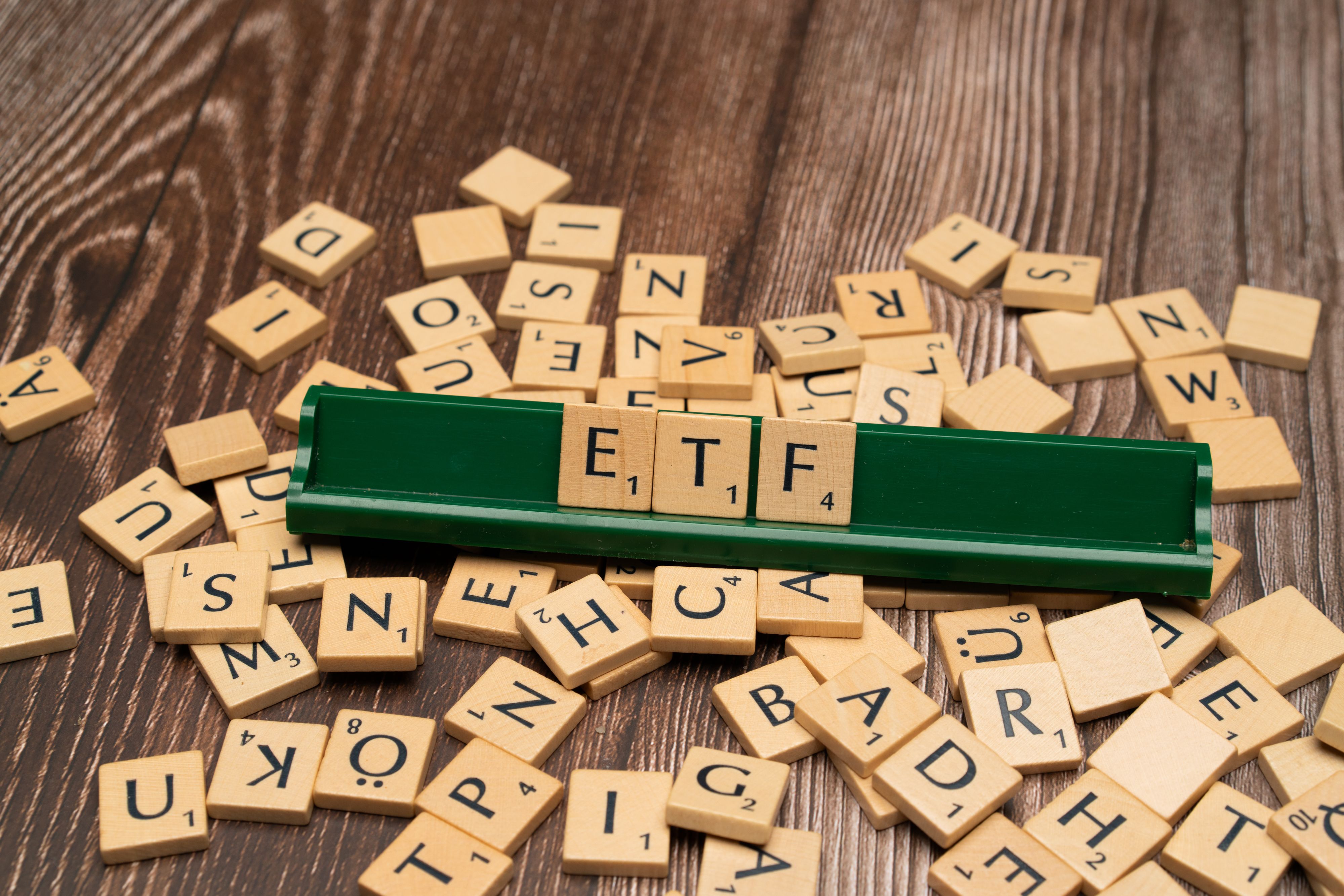 Lettres de Scrabble formant le mot ETF sur un plateau de bois