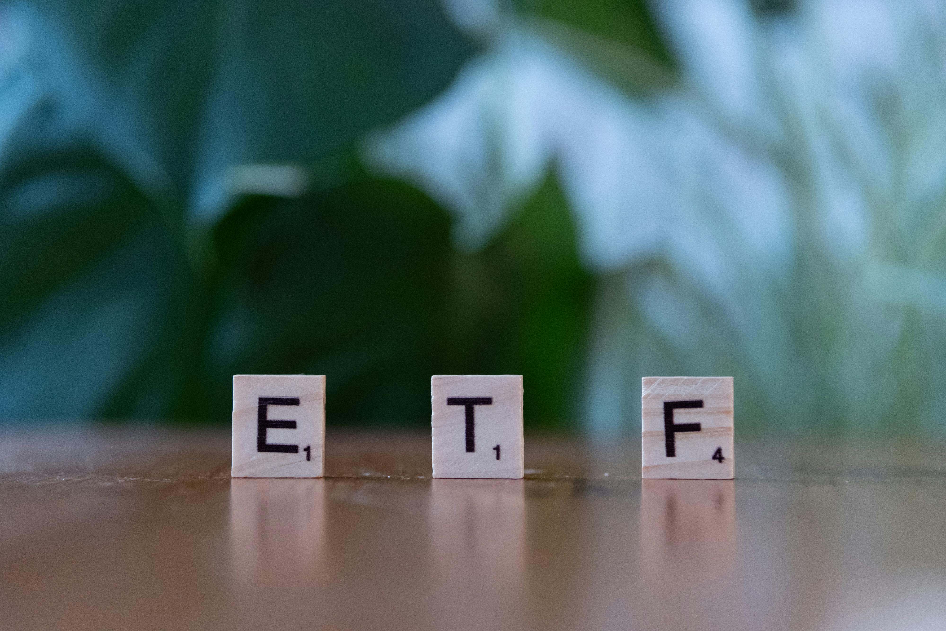 Cubes de bois formant le mot ETF devant une plante verte