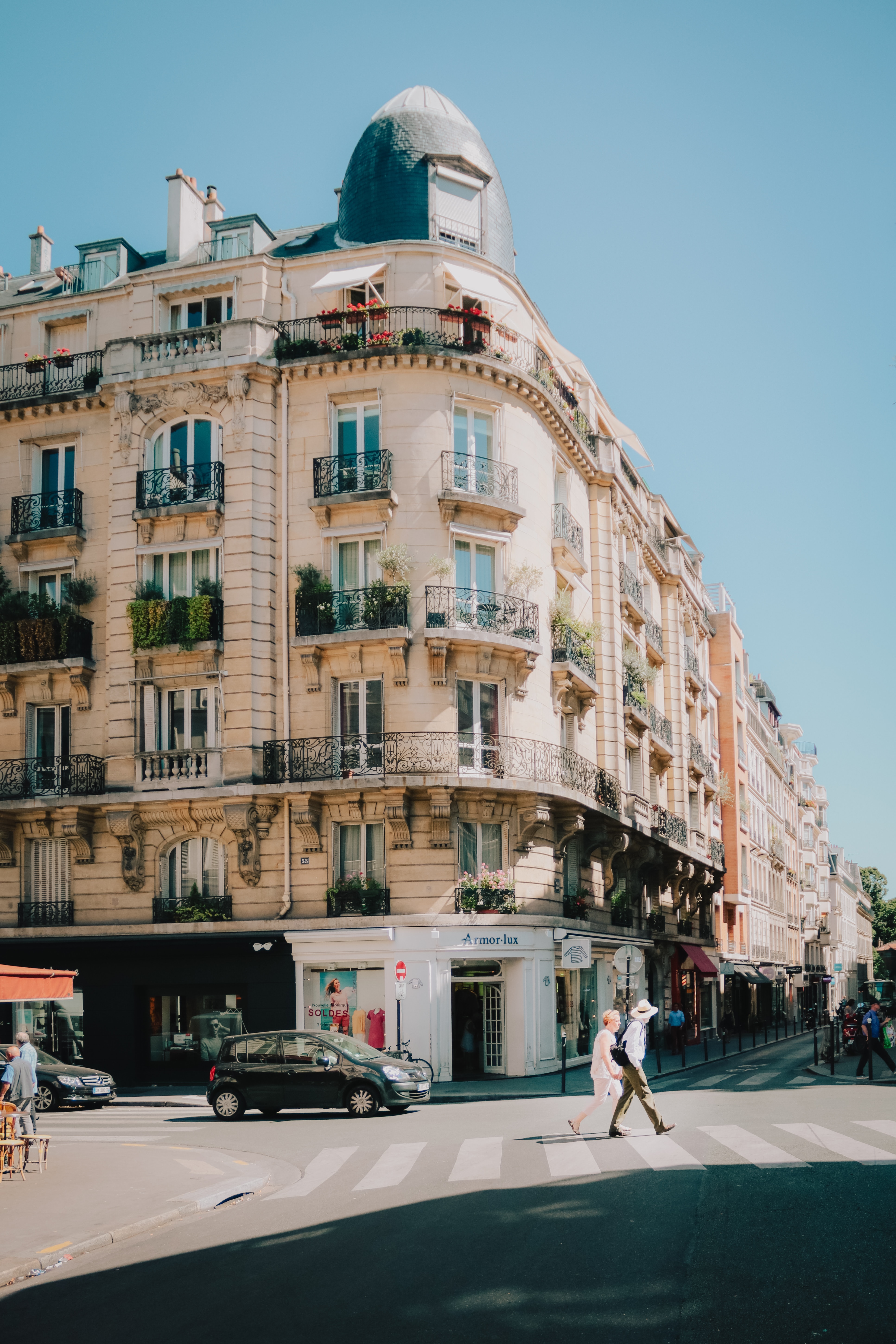 Immeuble d'angle aux façades claires dans une rue ensoleillée