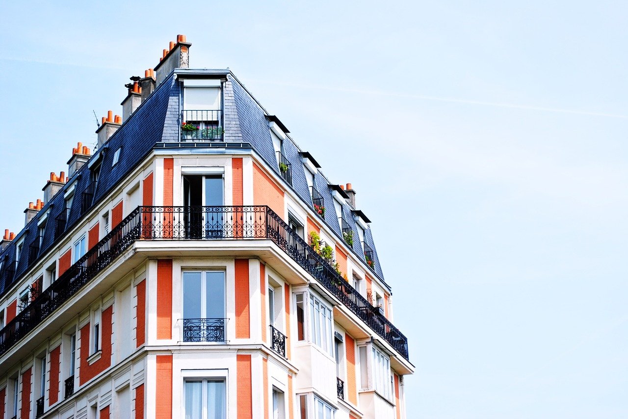 Immeuble ancien à l'angle de deux rues sous un ciel bleu