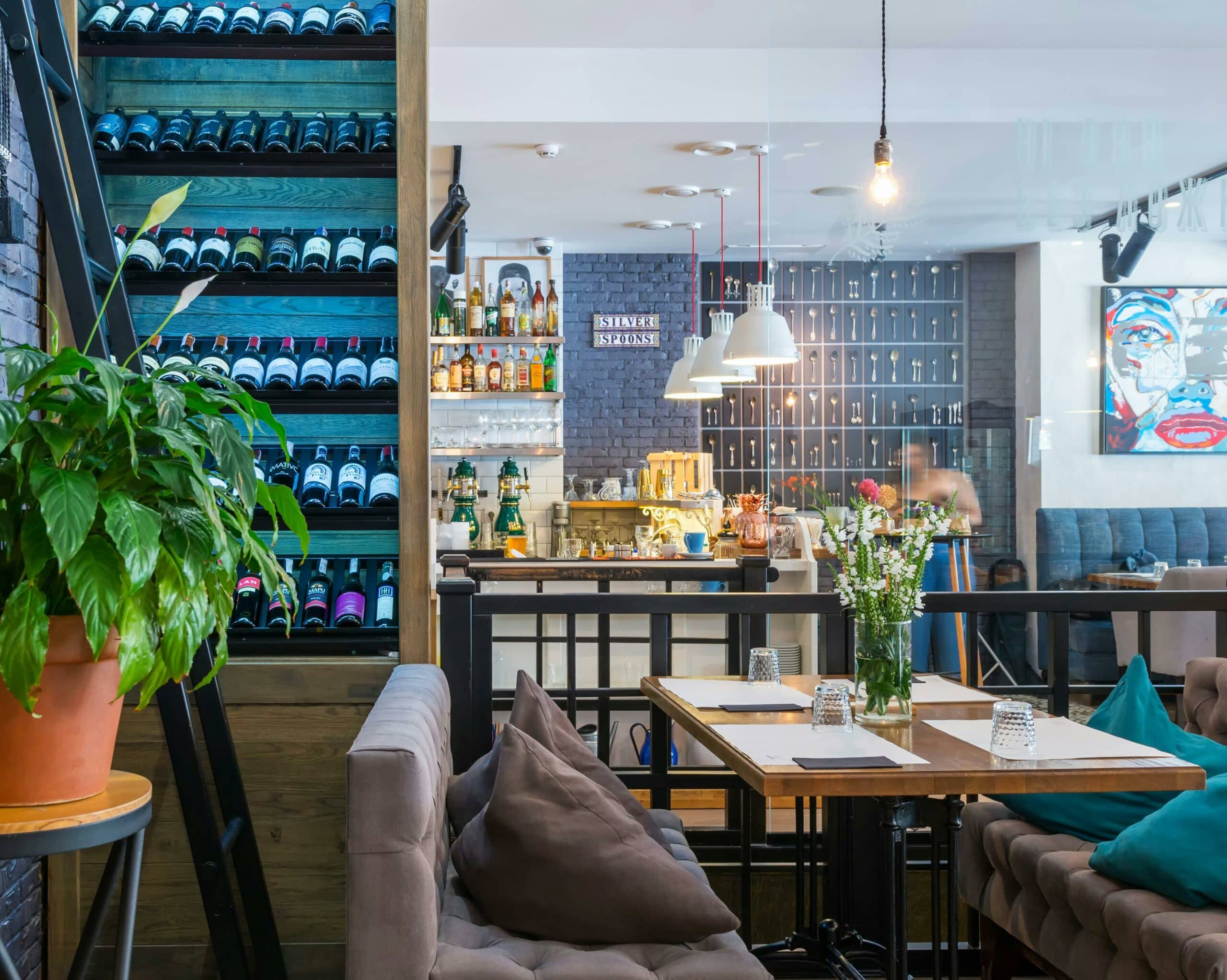 Salle d'un café aménagé avec banquettes et plantes