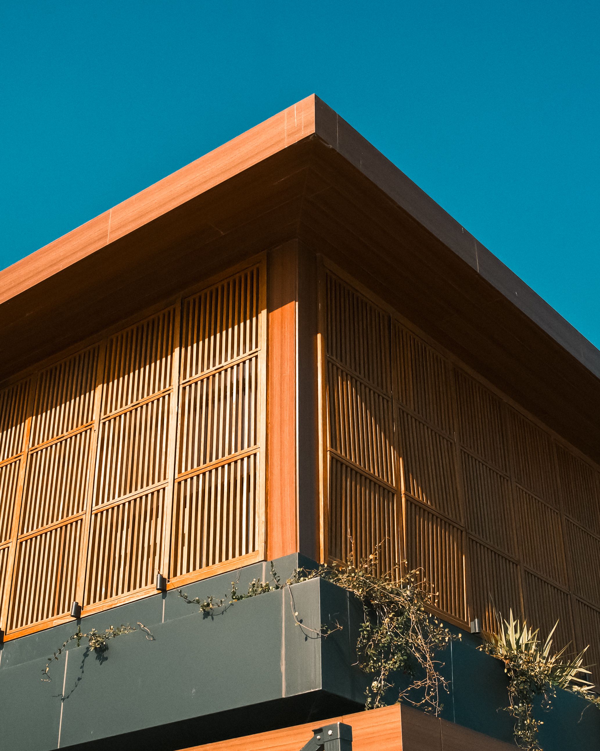 Angle d'un bâtiment contemporain habillé de brise-soleil en bois