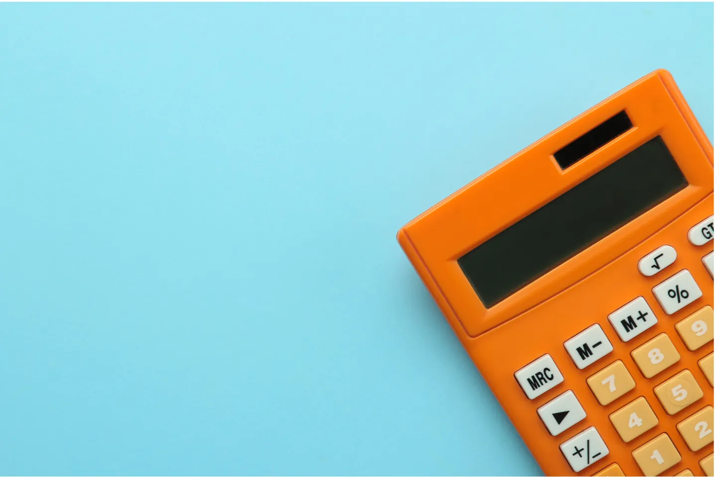 Calculatrice orange posée sur un fond bleu clair