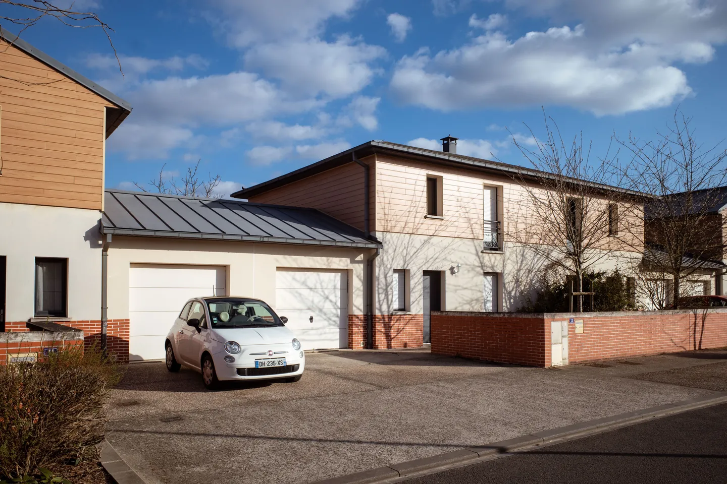 Maison neuve avec garage et voiture garée devant