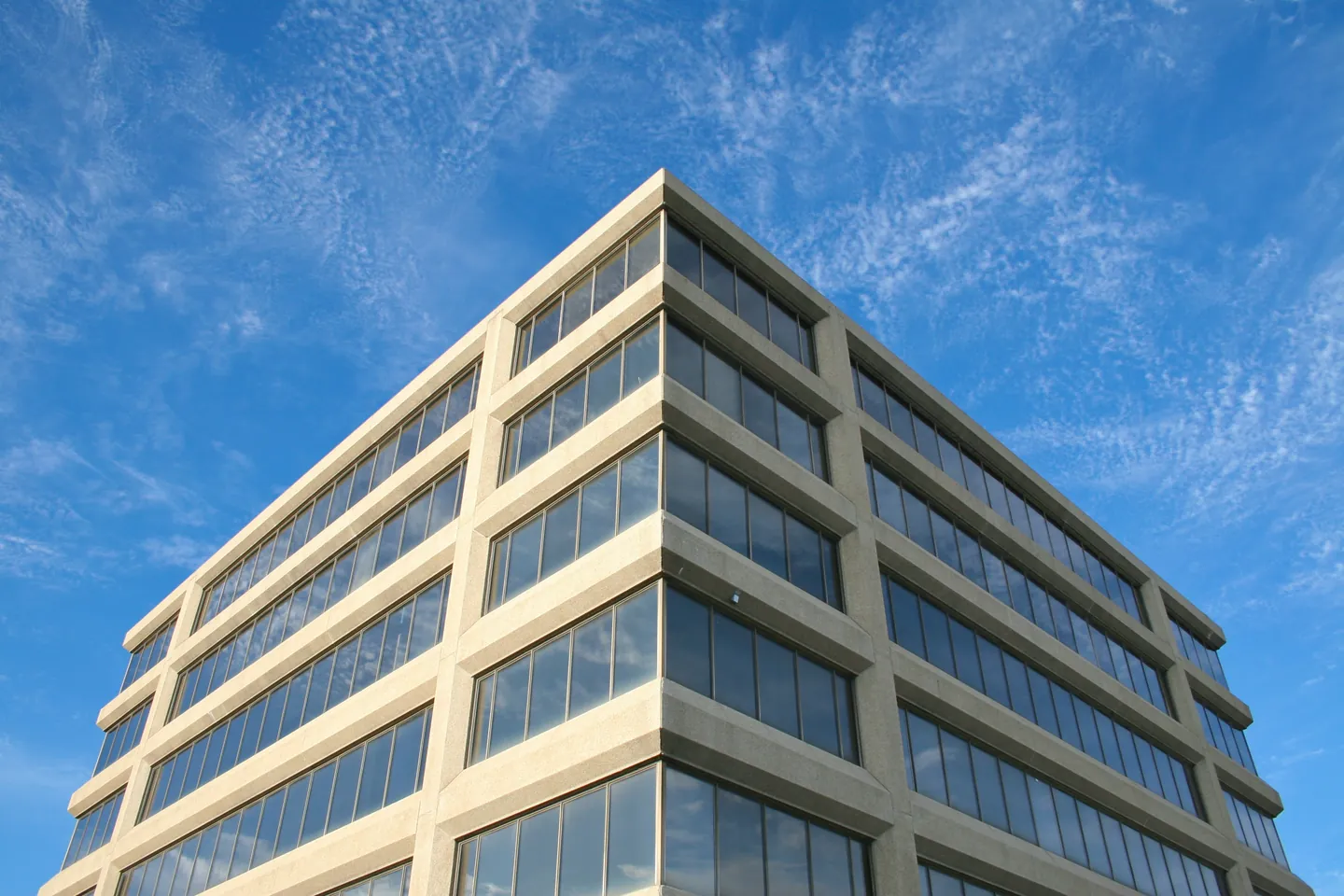 Angle d'un immeuble de bureaux moderne sous un ciel bleu