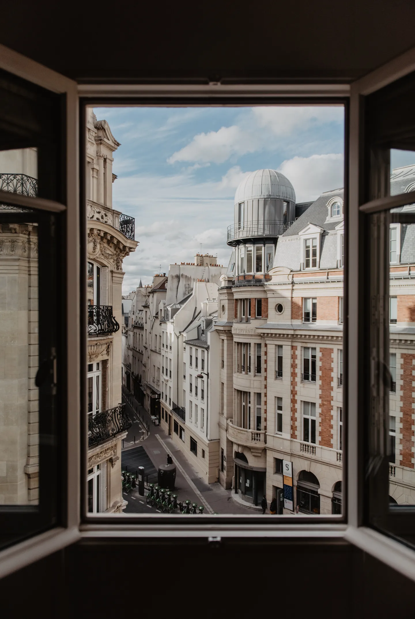 Ventana abierta que da a una calle de edificios antiguos