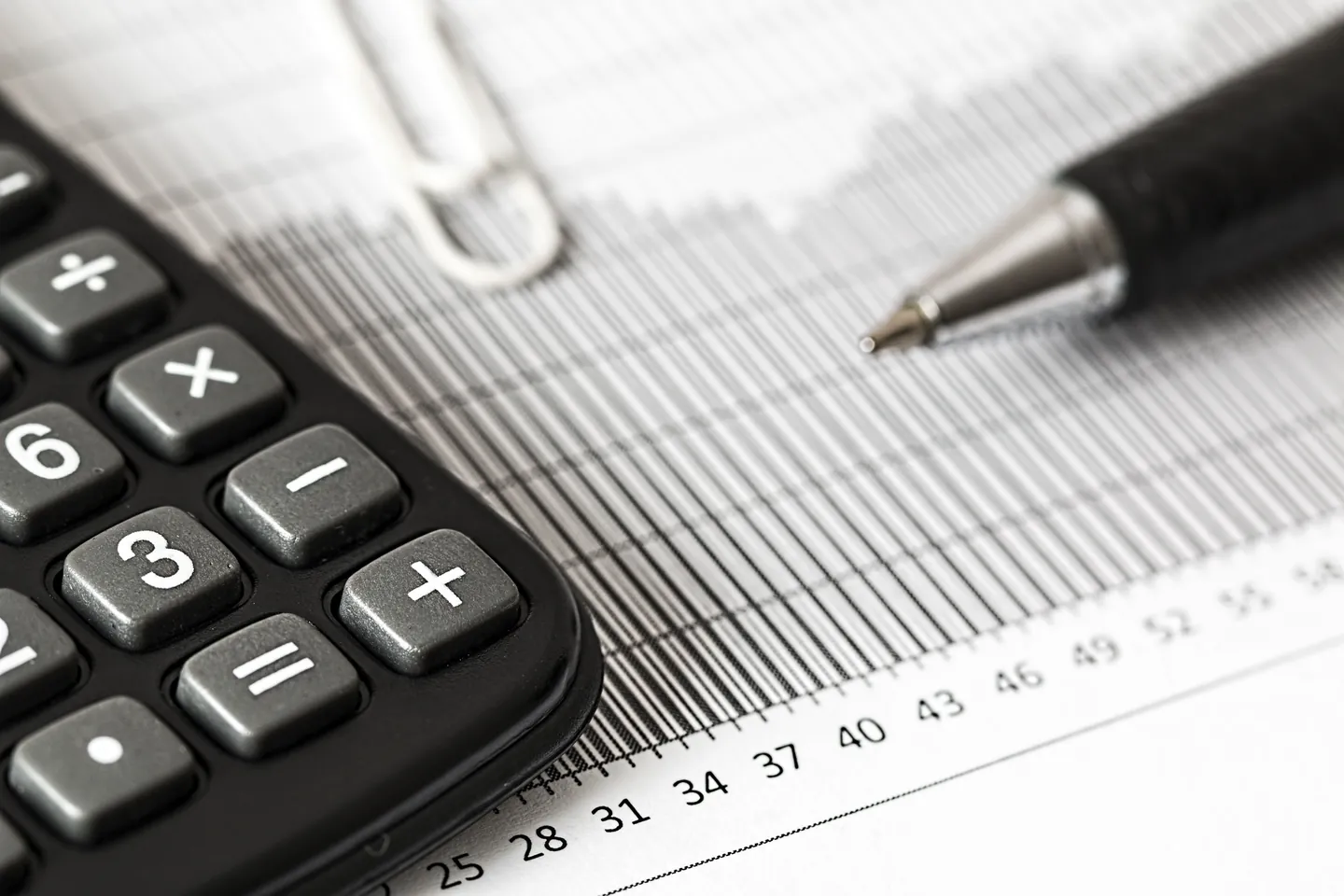 Calculatrice et stylo posés sur un tableau de chiffres