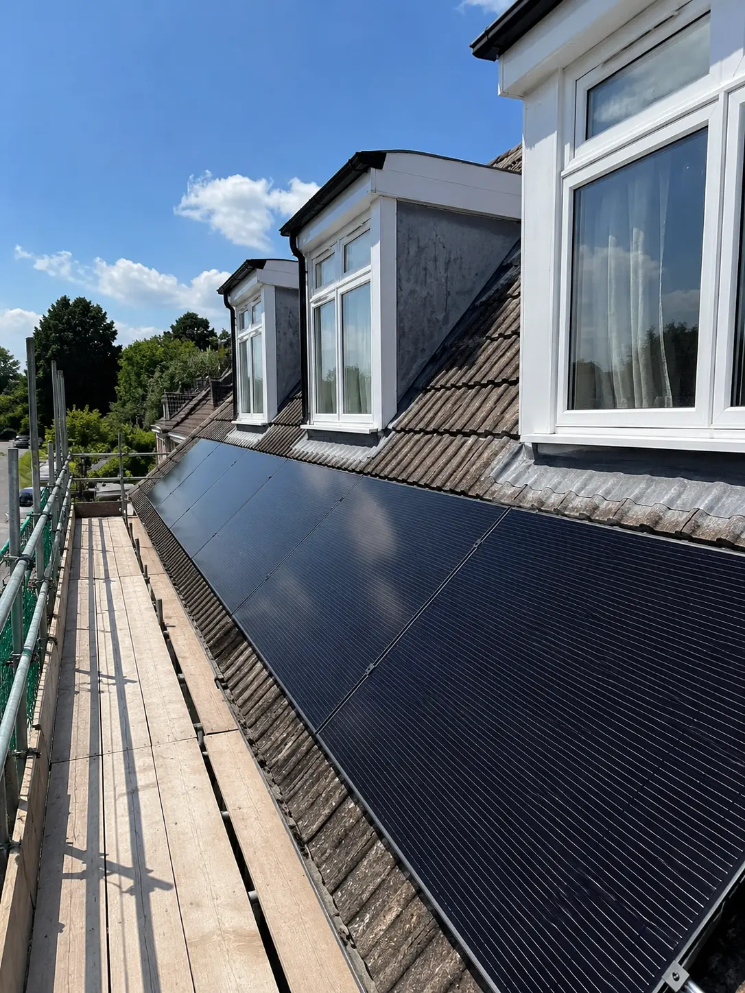 Solar photovoltaic panels installed on a residential rooftop as part of a housing retrofit and energy efficiency programme.