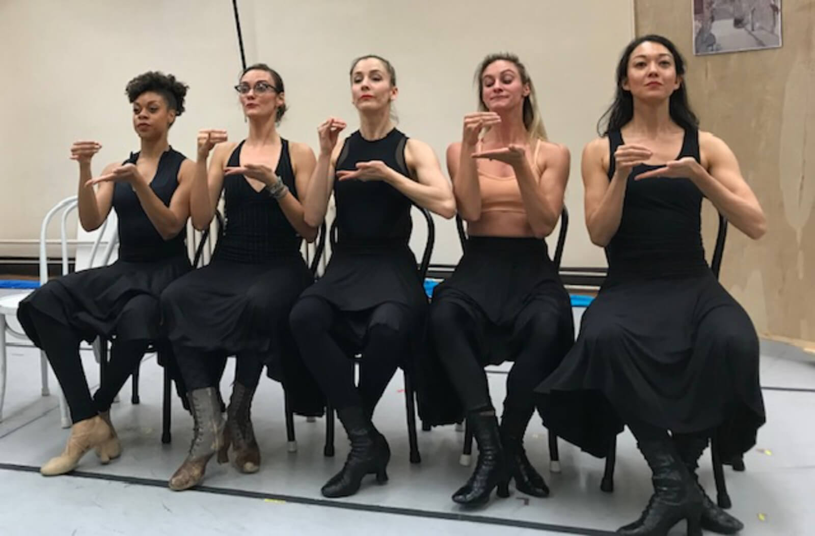 Rehearsal photo of the women in The Beast in the Jungle. The women mime having a cup of tea. 