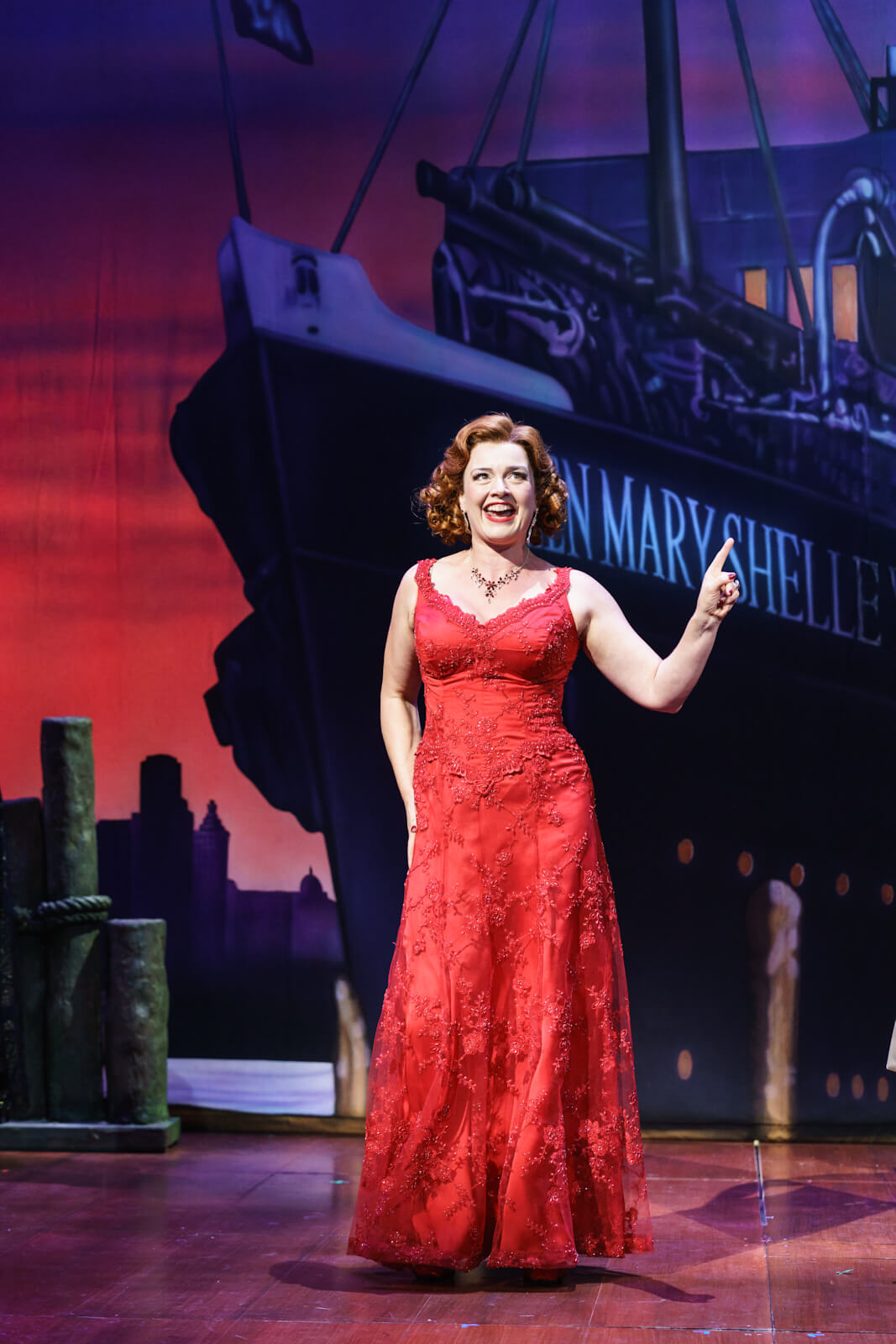 Elizabeth (Dianne Pilkington) is in a beautiful red dress saying goodbye to Frederick on the dock before he sails away to Transylvania. 