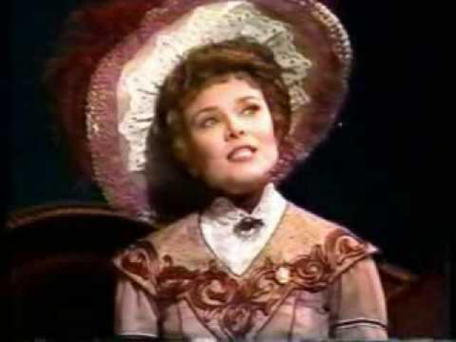 Maureen Moore as Countess Charlotte singing "Everyday a Little Death". She is wearing beautiful turn of the century hat and dress with white lace and peach embroidery. 