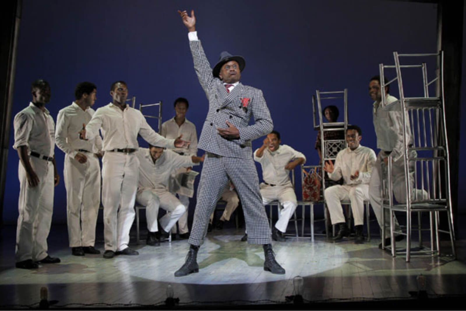 Mr. Tambo (Forrest McClendon) sings "Thats Not the Way We Do Things" surrounded by The Scottsboro Boys. He is playing the role of lawyer Sam Leibowitz. They are all in a jail cell.