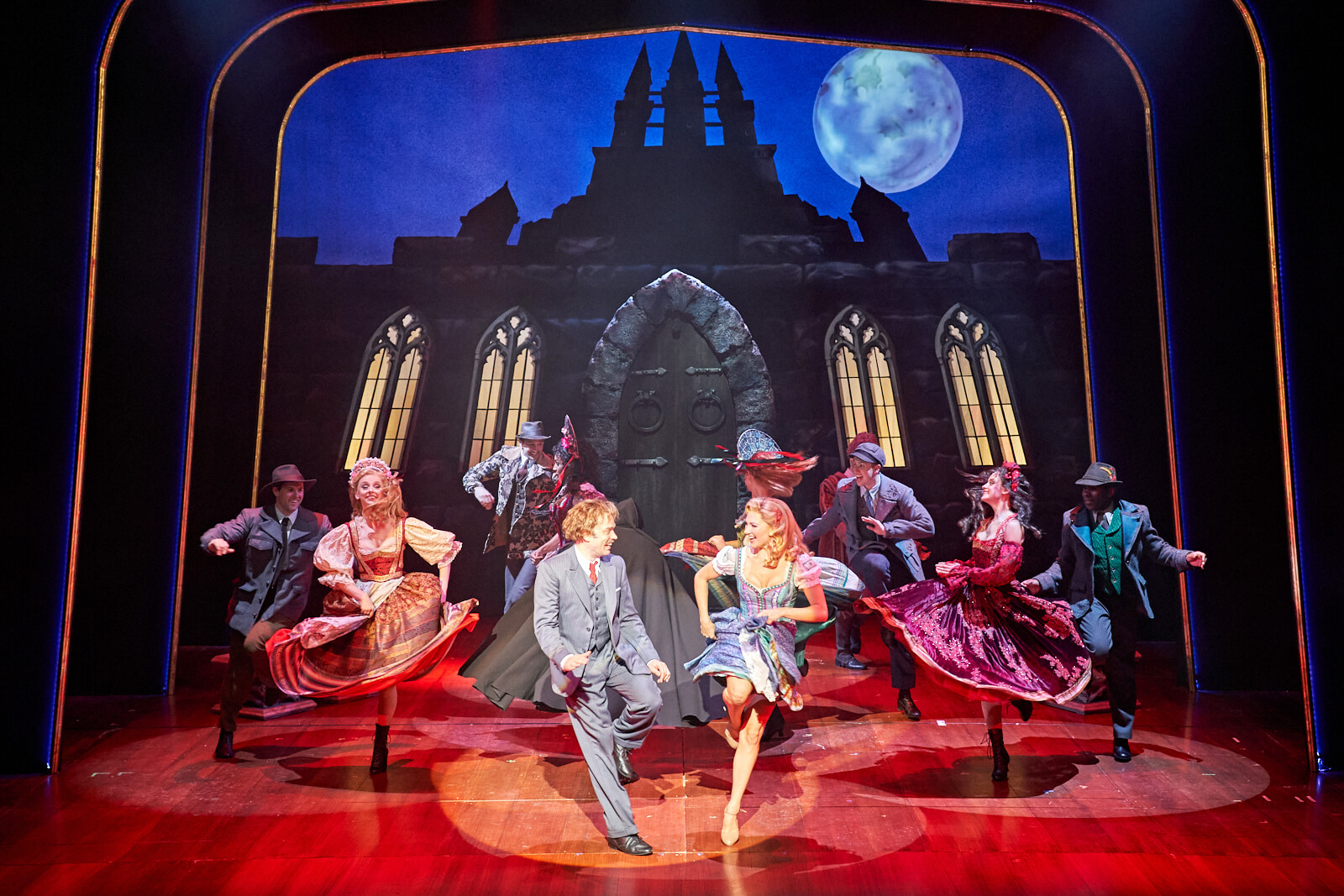 Dr. Frankenstein (Hadley Fraser) and Inga (Summer Strallen) dancing to "Transylvania Mania" under a full moon in front of the castle with happy villagers.