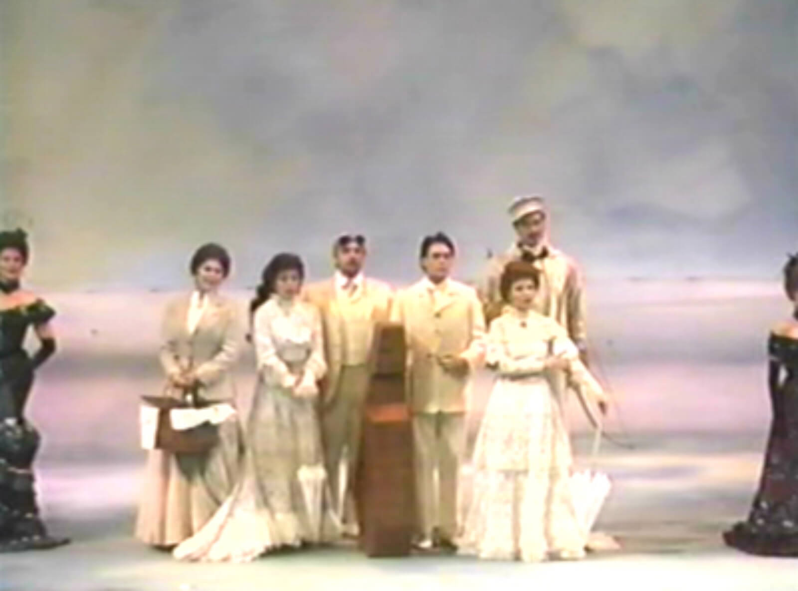 The cast of A Little Night Music singing "A Weekend in the Country". They are dressed in white traveling garb standing in front of a Monet-like background.