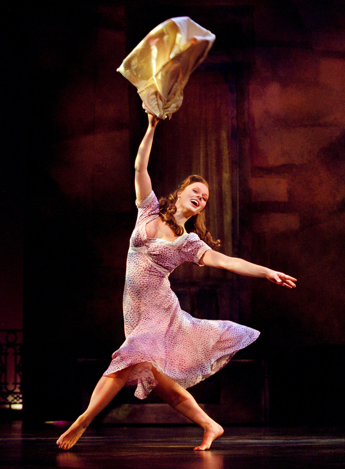 Therese Raquin (Kate Levering) all smiles, swinging her laundry.