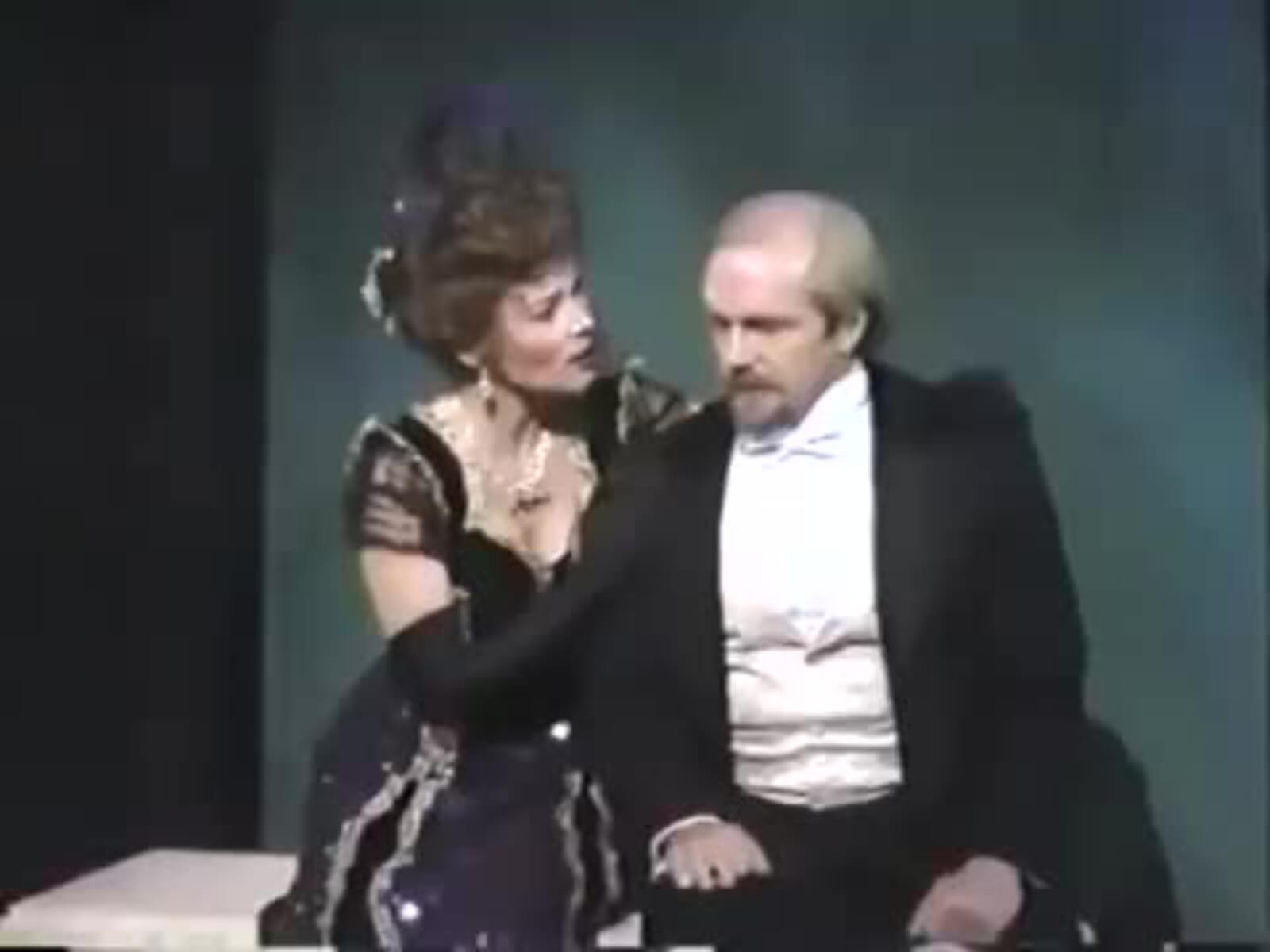 Maureen Moore as Countess Charlotte and George Lee Andrews and Frederik Egerman. Charlotte is consoling Frederik because his son ran off with his young wife. They are dressed in black tie and an elegant gown in A Little Night Music. 