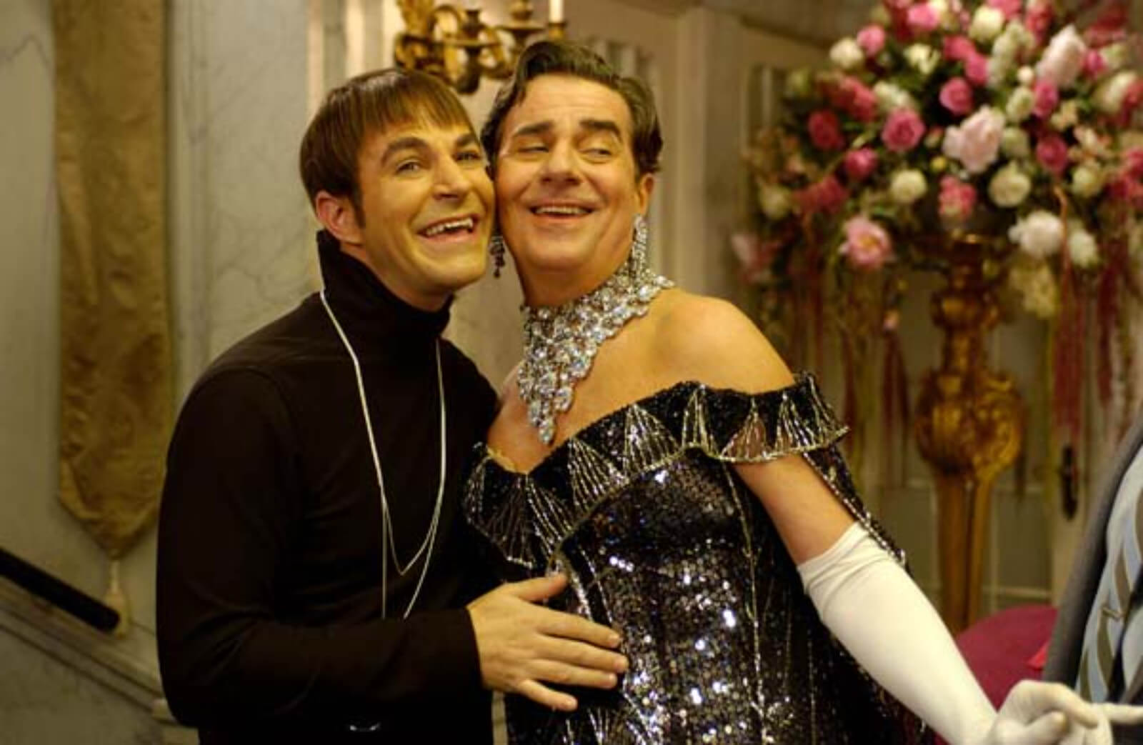 Carmen Ghia (Roger Bart) and Roger De Bris (Gary Beach) singing cheek to cheek. Roger De Bris is dressed in a gown that looks like the Chrysler Building. 