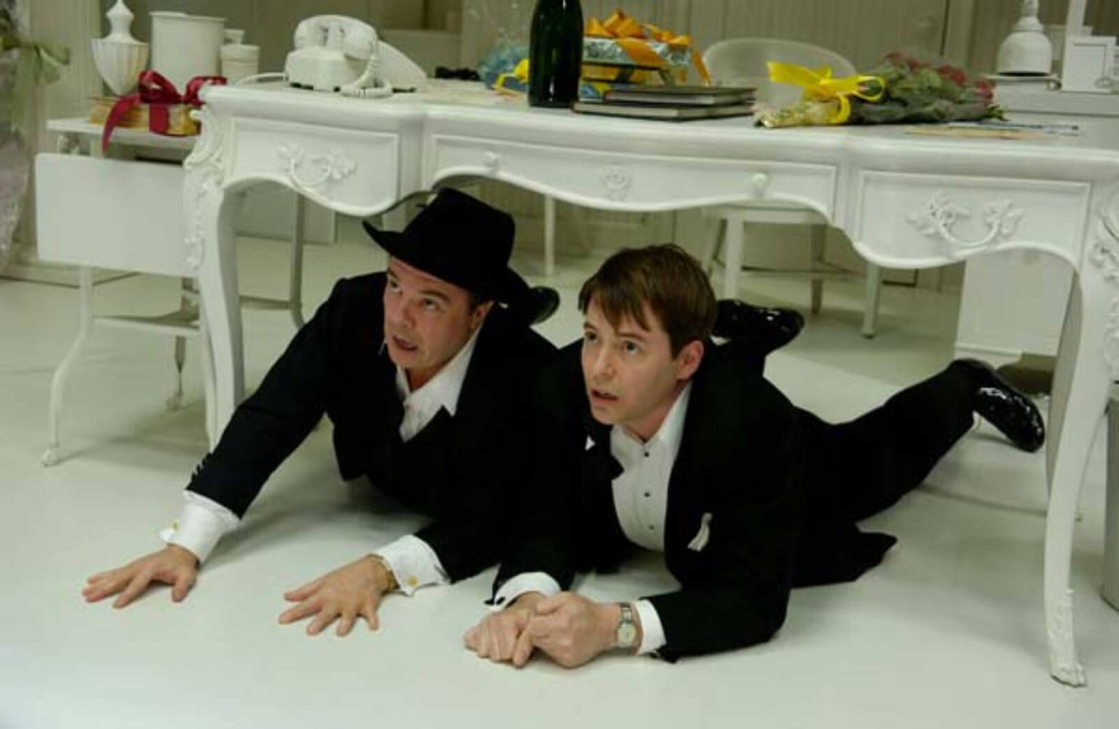 Max Bialystock (Nathan Lane) and Leo Bloom (Matthew Broderick) hiding under the desk.