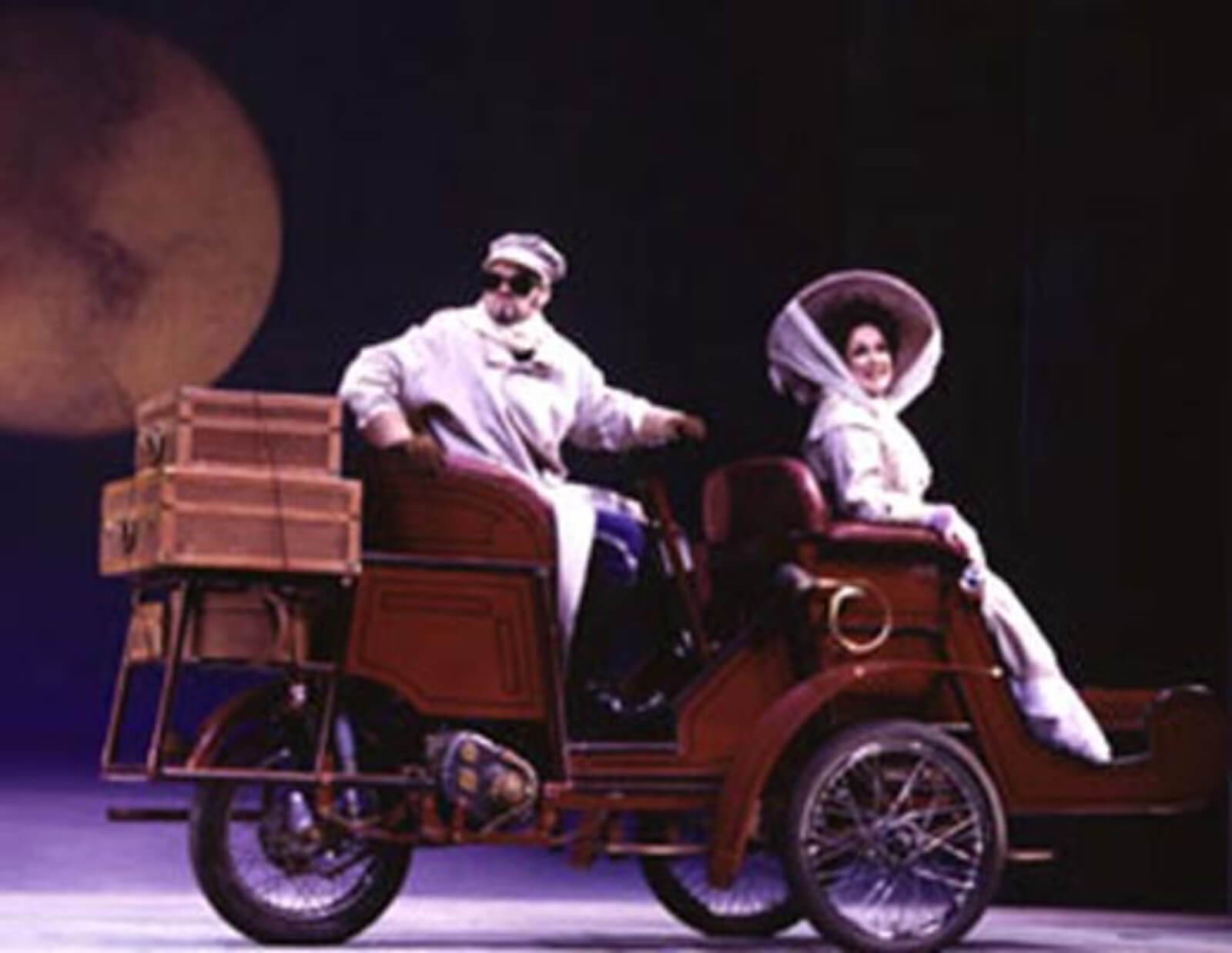 Marc Kudisch as Count Carl-Magnus driving Charlotte. He is in a long white coat and she is dressed in a white traveling gown. 