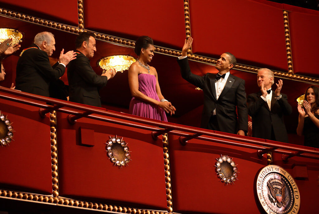 President Barack Obama waving to the Kennedy Center Awards Honorees with Michelle Obama.