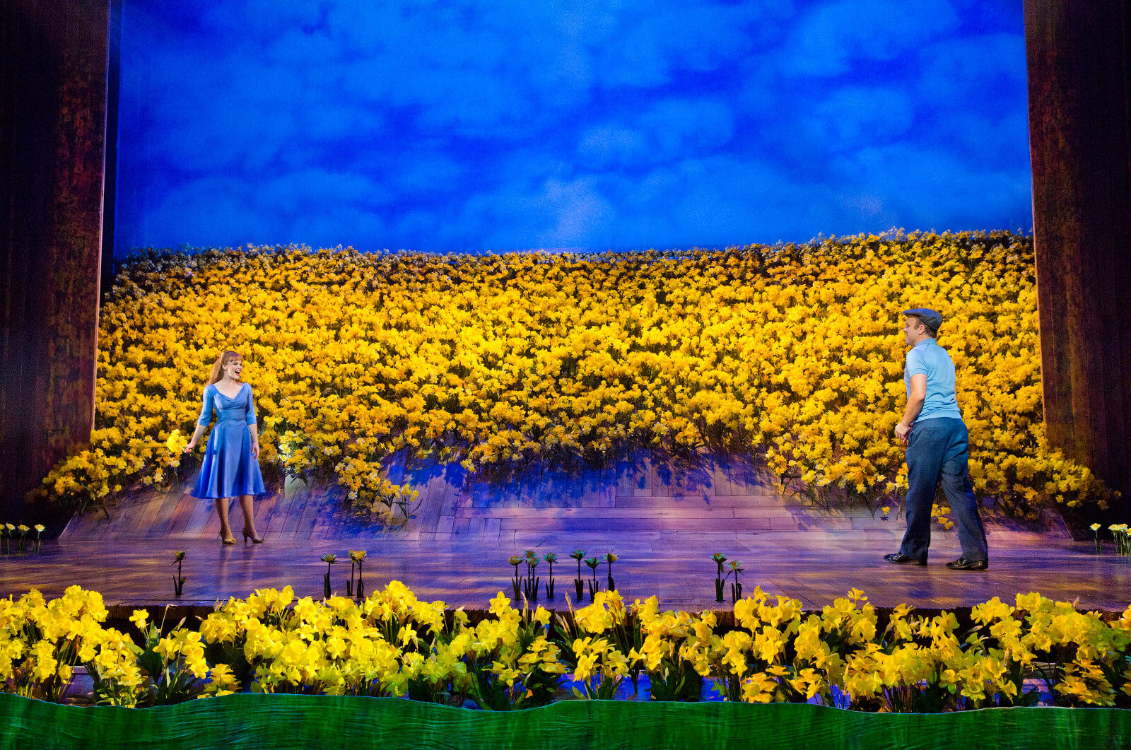 Sandra (Kate Baldwin) and Edward Bloom (Norbert Leo Butz) look at each other across a field of daffodils‍